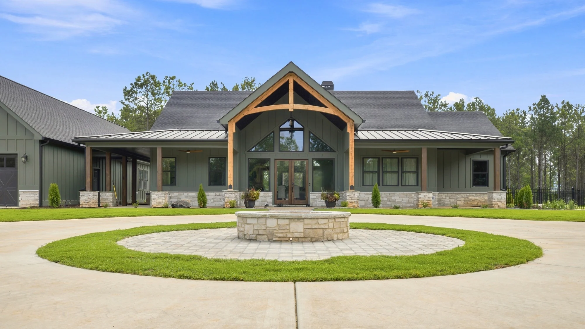 A finished BDS Landscaping entry court on Holland Chattoogaville Road in Rome, Georgia — stone fire feature on a paver island, ringed with new turf